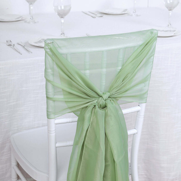 Green chair sash tied in a bow on a white chair at a dining table.