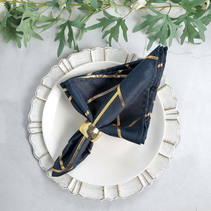 Elegant navy napkin with gold stripes, styled on a decorative plate.