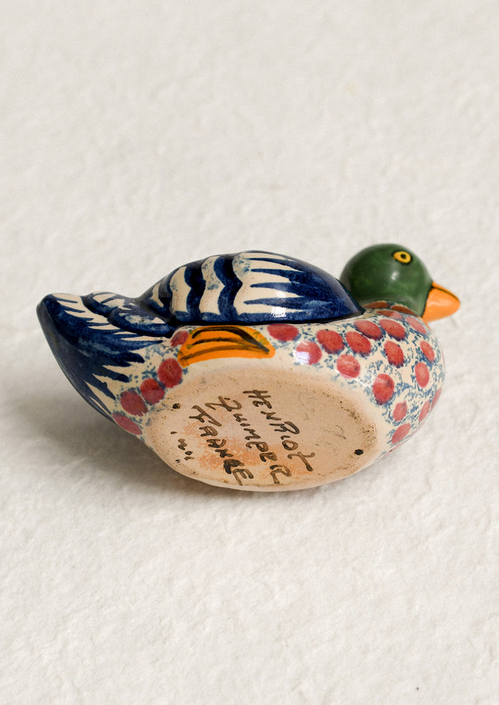 A hand-painted egg cup in the shape of a duck.