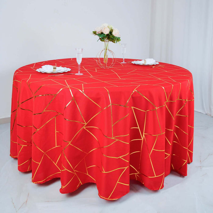 Red tablecloth with gold geometric pattern on a round table.