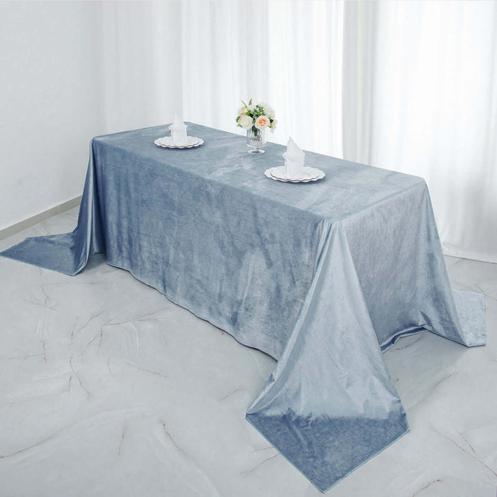 Elegant blue tablecloth on a dining table with napkins and flowers.