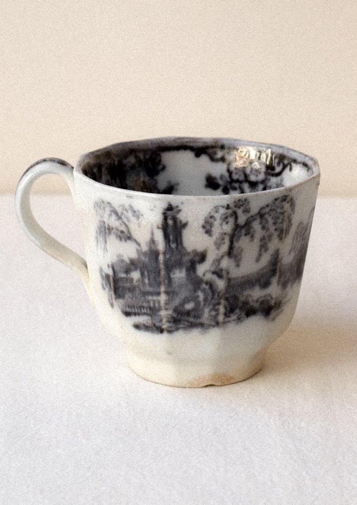 Ceramic mug with black and white design on a beige background