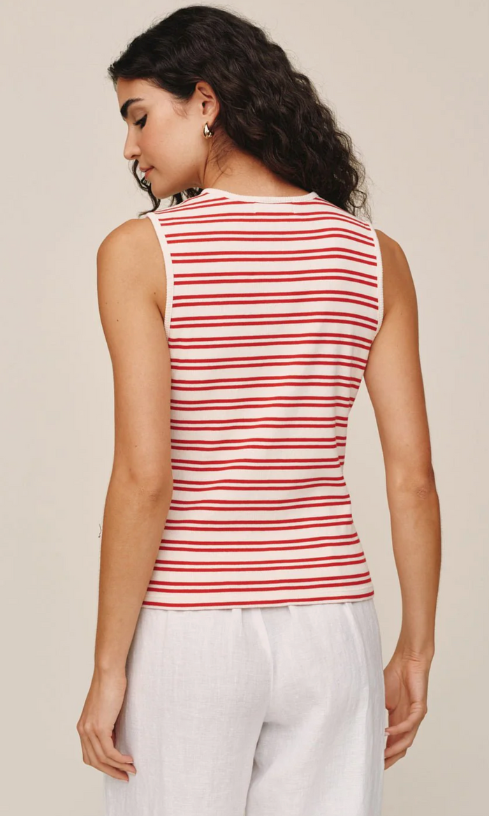 Woman wearing a red and white striped sleeveless top against a beige background
