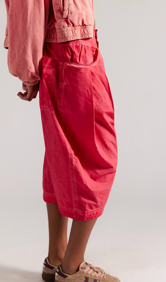 Person wearing red pants and a pink jacket on a white background