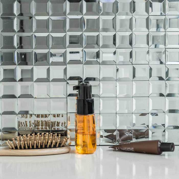 Hair care products on a reflective surface with hairpins and a brush.