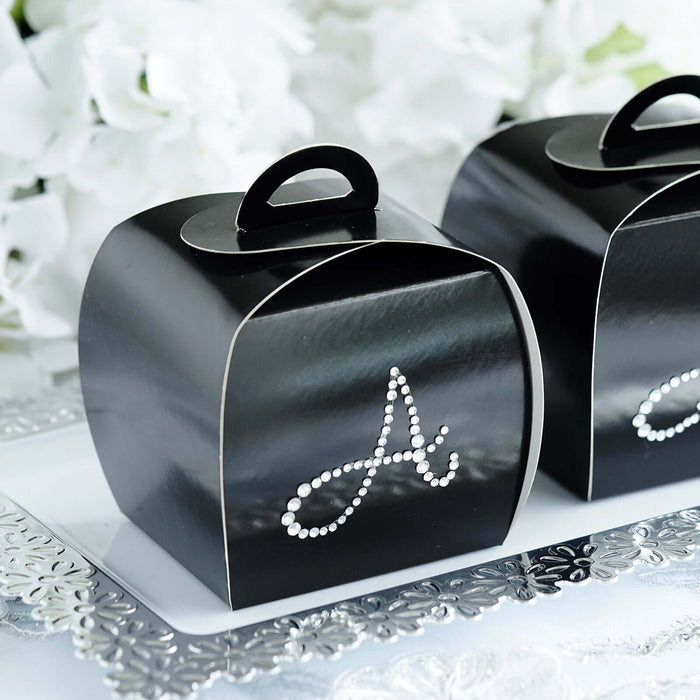 Black gift boxes with decorative white letter "A" design.