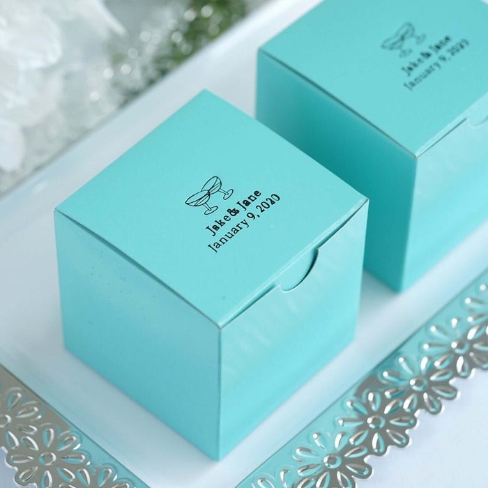 Turquoise gift boxes with personalized labels for a wedding.
