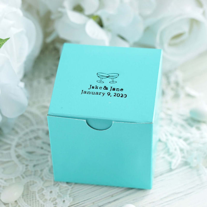 Personalized wedding favor box in turquoise with printed names and date.