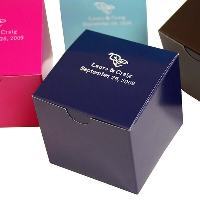 Personalized wedding favor boxes in various colors with custom text.