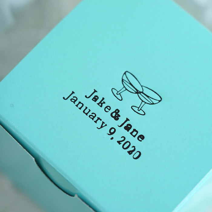 Personalized teal wedding favor box with couple's names and date.