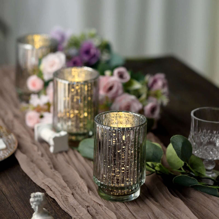 Decorative glass candle holders with gold accents and floral arrangement