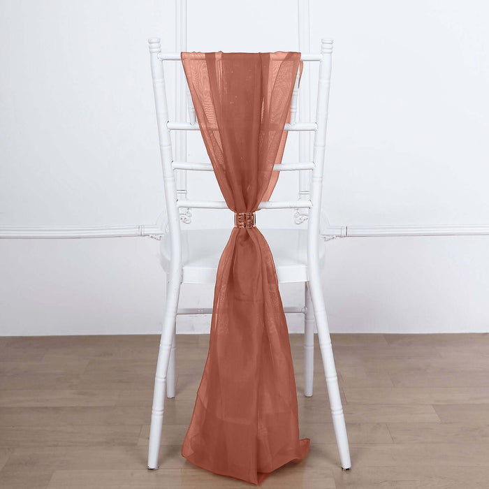 Sheer rust-colored fabric draped on a white chair.