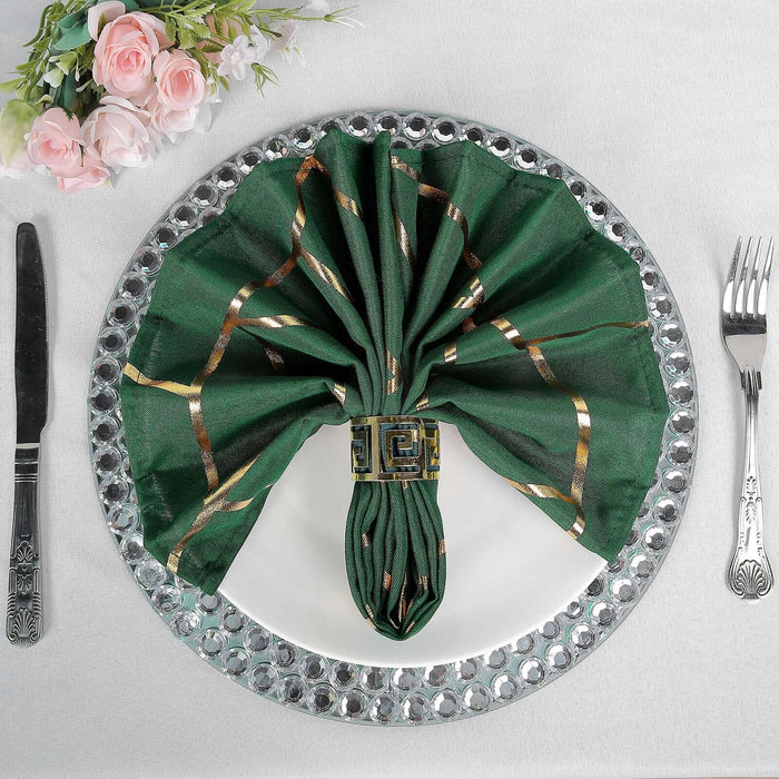 Elegant green napkin styled with gold accents on a decorative plate.