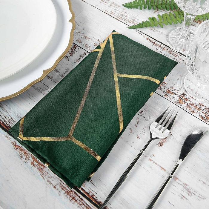 Green napkin with gold geometric design, styled for dining table setting.