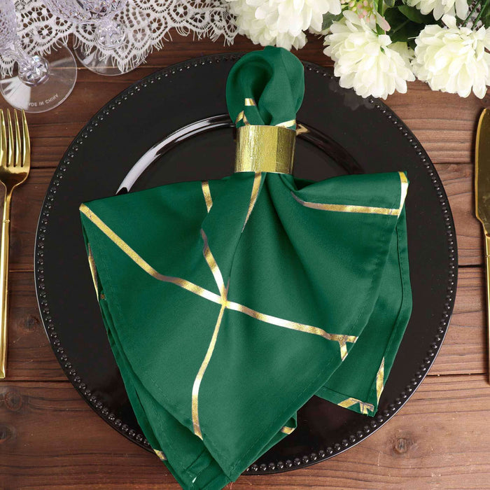 Green napkin with gold accents elegantly arranged on a black plate.