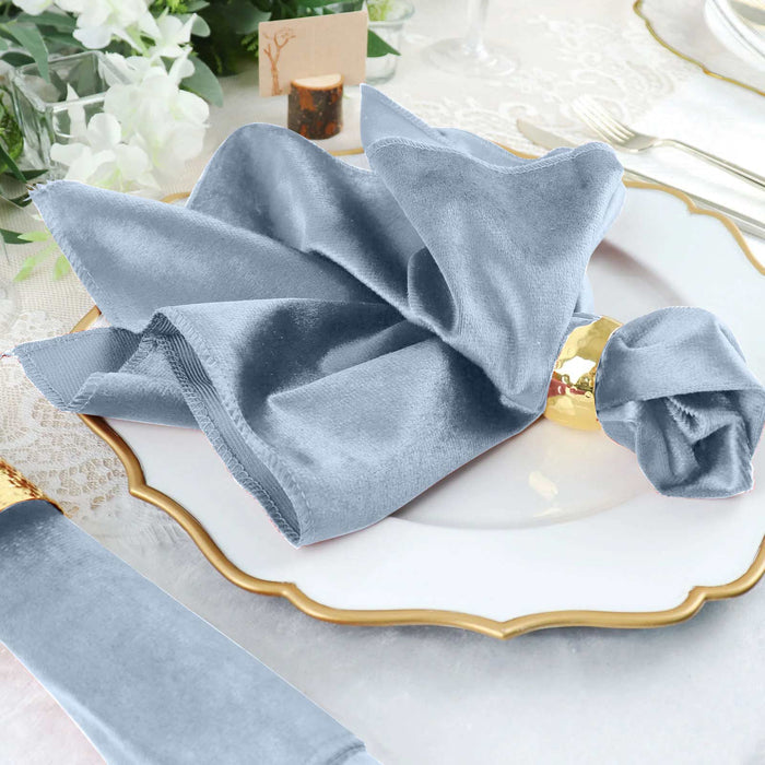 Elegant blue velvet napkin elegantly styled on a fine dining plate.
