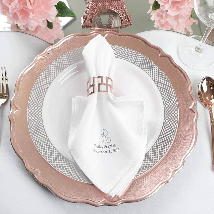 Elegant table setting with pink charger plate, white napkin, and floral decor.