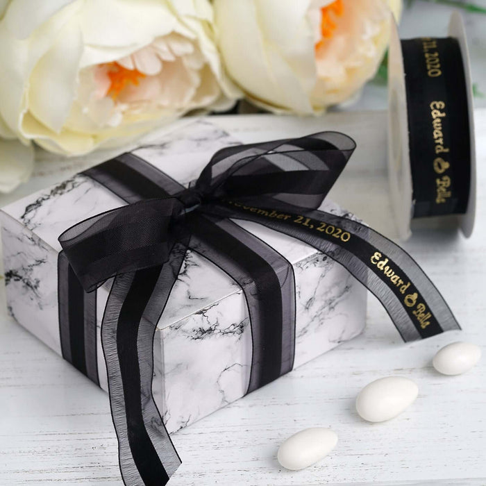 Marble-patterned gift box with black ribbon and decorative candies