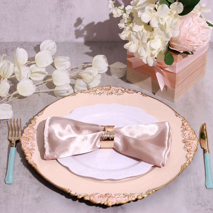 Elegant pink satin napkin on a decorative plate with floral centerpiece.