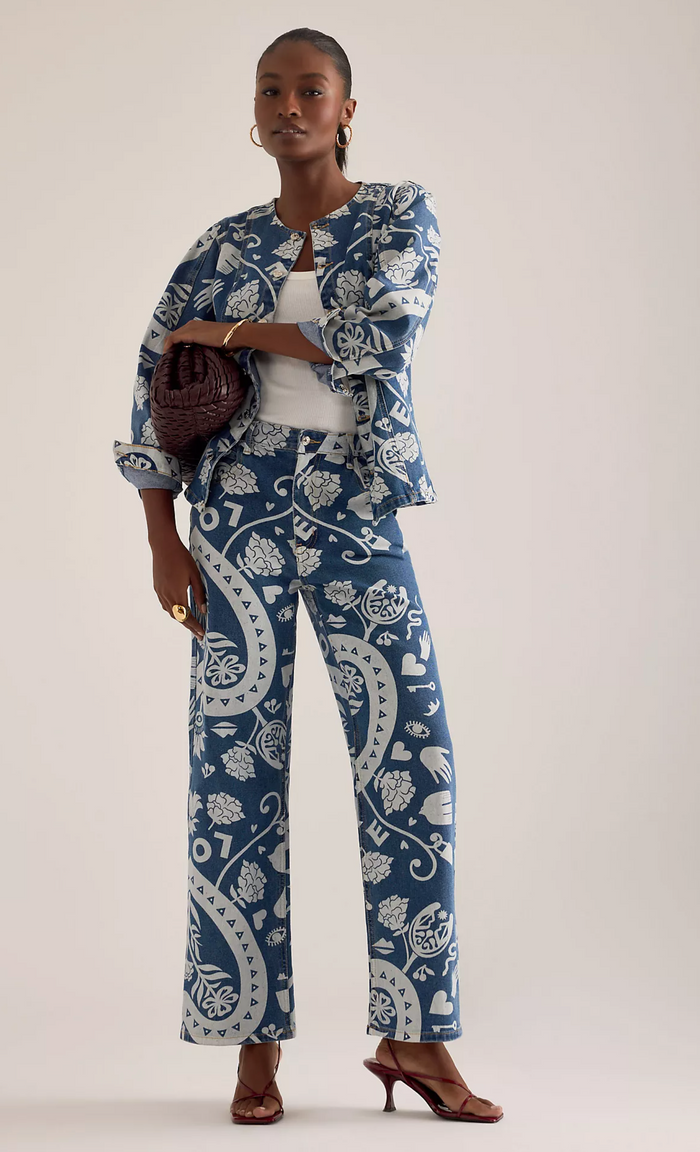 Woman wearing a blue and white patterned outfit on a plain background