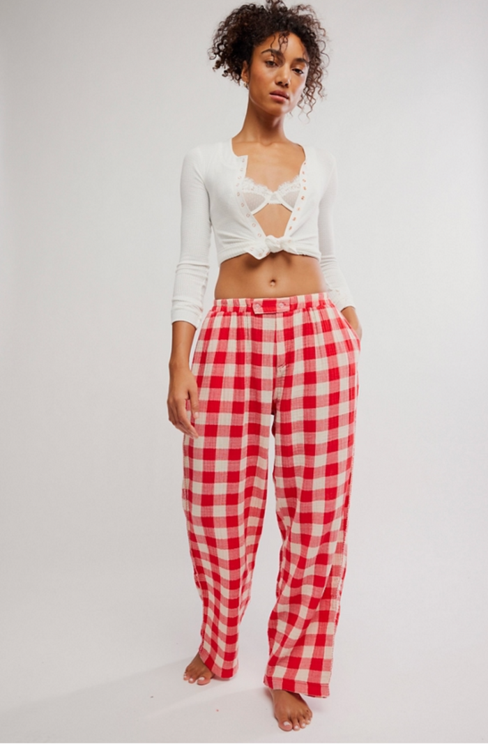 Woman wearing a white top and red checkered pants on a white background