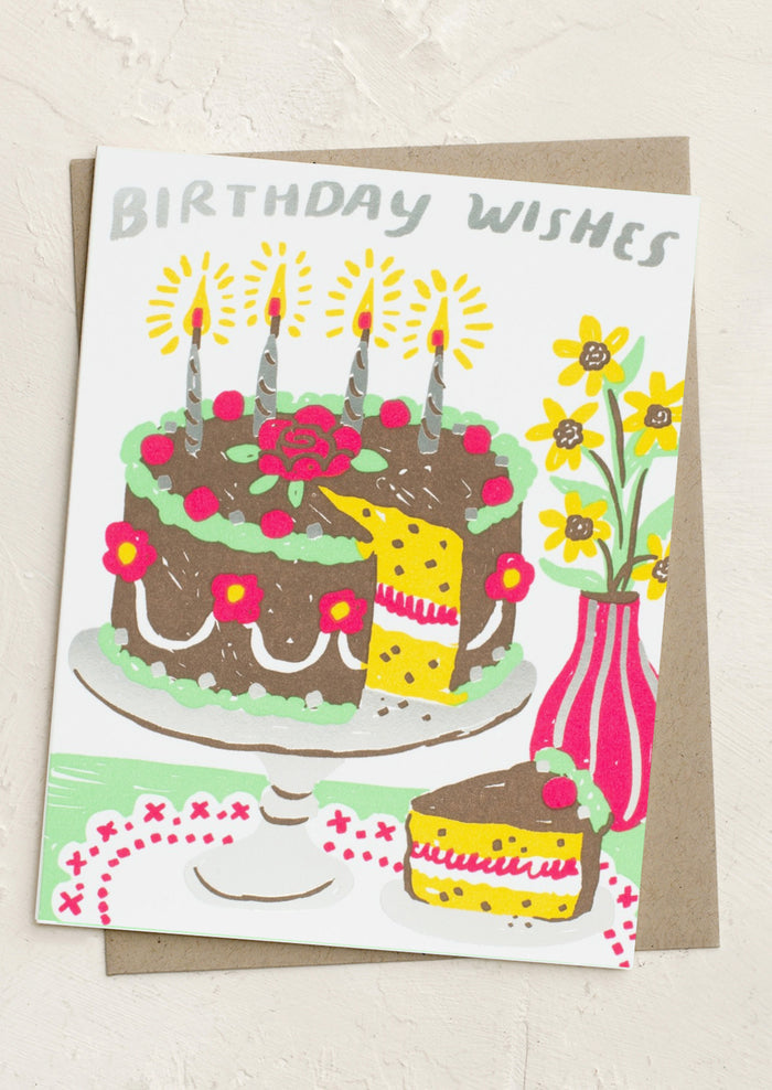 A card with scene of cake and vase with flowers on table, text at top reads "Birthday wishes!".