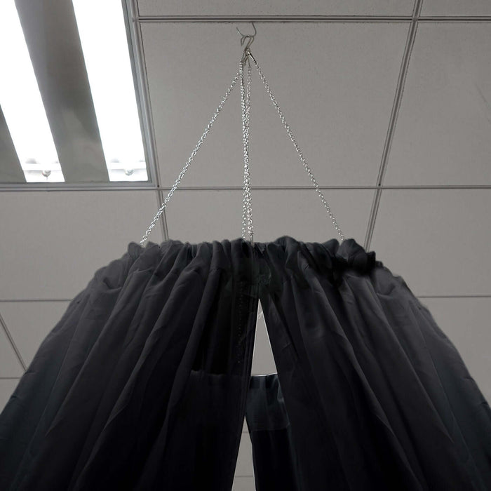 Black sheer curtain hanging from a chain in a ceiling mount.
