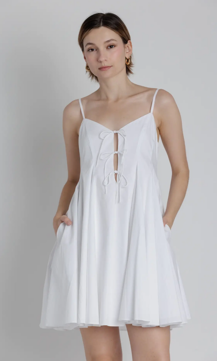 Woman wearing a white dress against a plain background