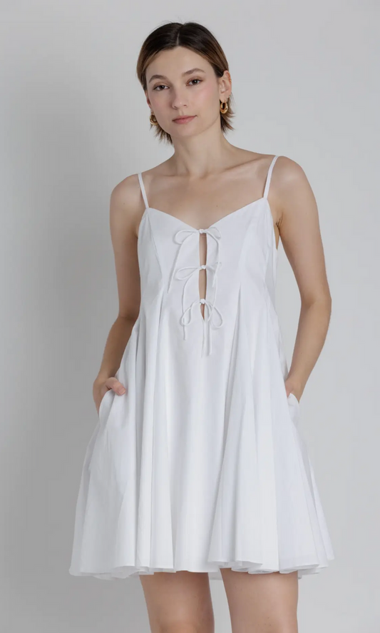 Woman wearing a white dress against a plain background