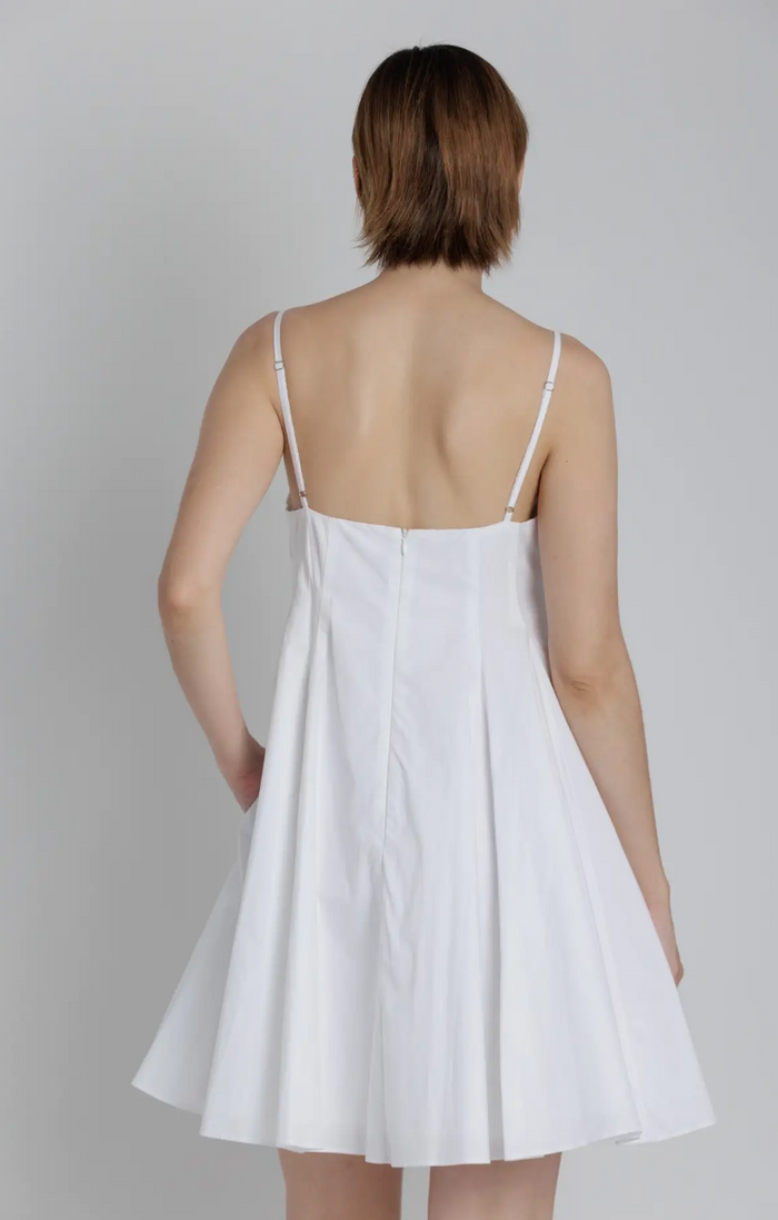 White dress worn by a person on a plain background