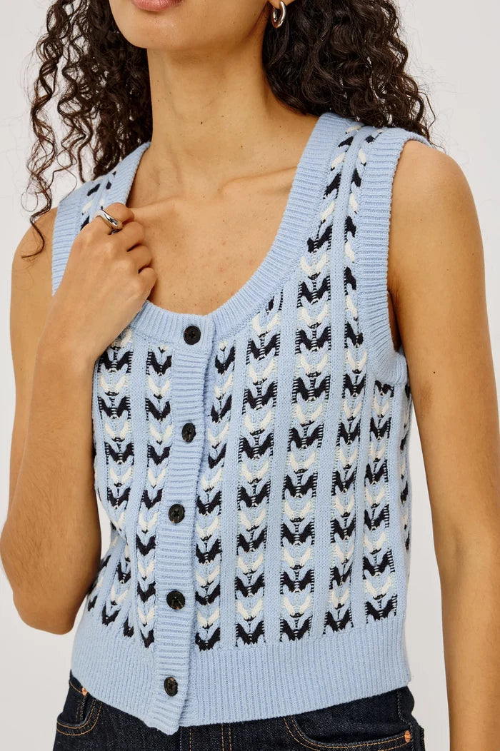 Light blue sleeveless knitted vest with black and white pattern worn by a person.