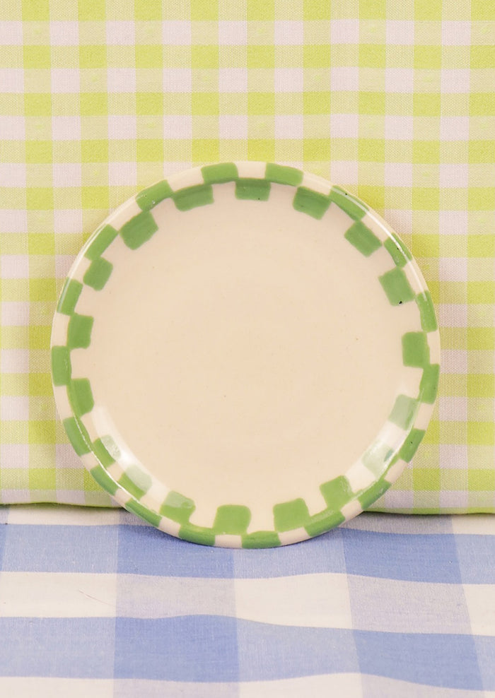 A round ceramic trinket dish with green checkered border.