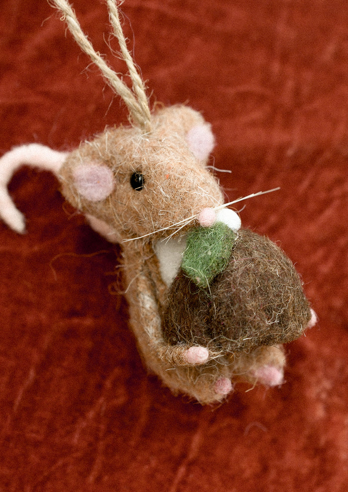 Felted brown mouse ornament holding pudding.