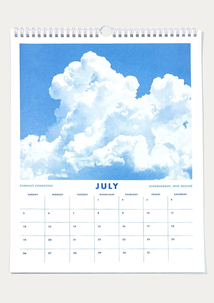 Calendar page for July with a blue sky and cloud background