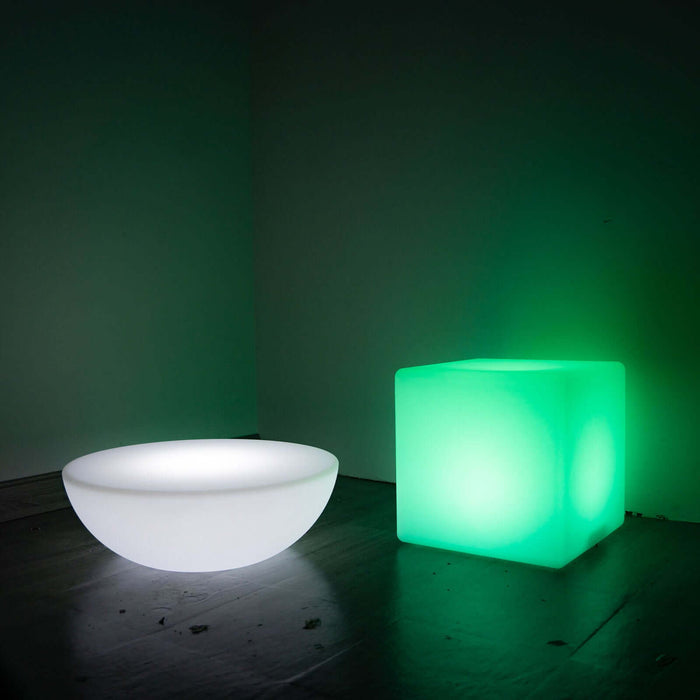 Modern illuminated bowl and cube in green and white lighting.