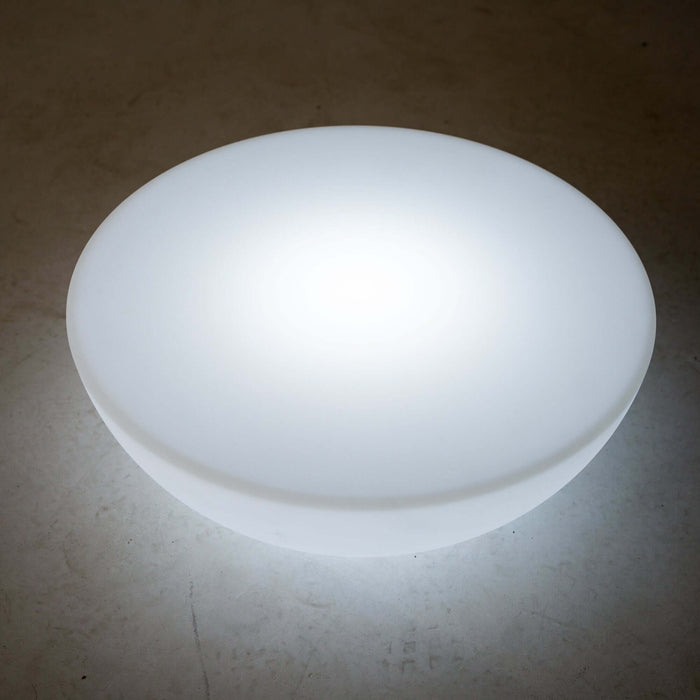 Round glowing white light fixture on a plain background