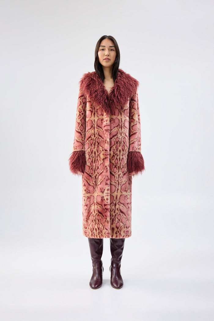 Pink and beige animal-print faux fur coat with contrasting burgundy collar and cuffs, full-length relaxed fit, worn over burgundy knee-high boots, front view