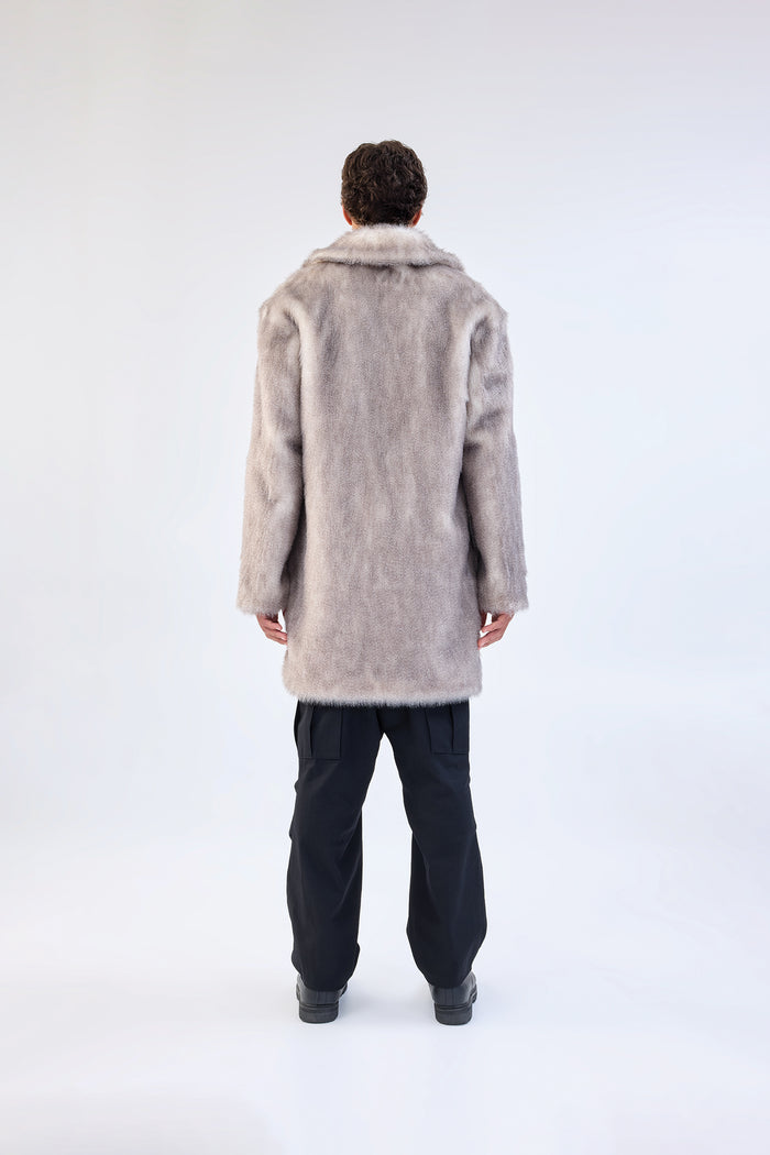 Grey faux fur coat with notch lapel and mid-length relaxed fit, worn over a black top and trousers, back view