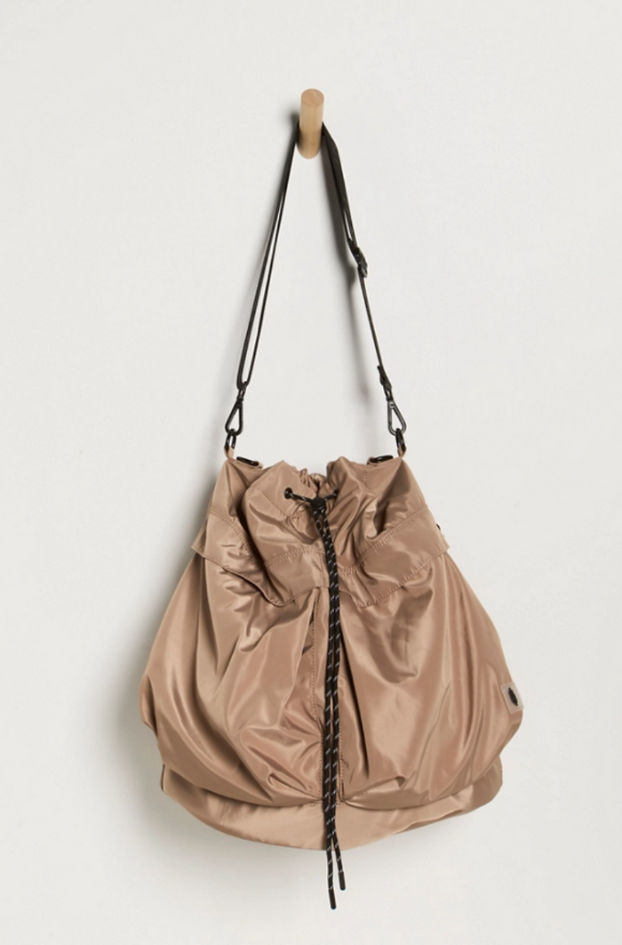 Free People Ego Boost Bucket Sandy hanging from wooded peg on white wall