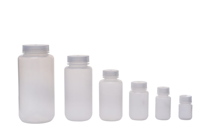 Set of white plastic bottles with silver caps on a white background