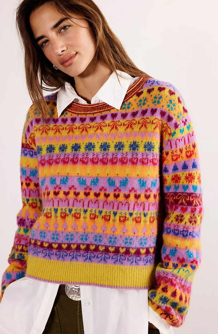 Woman wearing a colorful patterned sweater on a white background