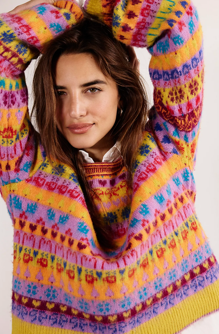 Woman wearing a colorful patterned sweater against a white background