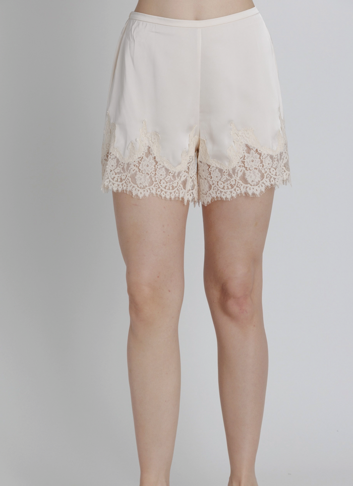 Champagne-colored lace-trimmed shorts on a plain background