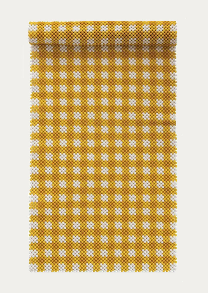 A beaded table runner in yellow and white gingham pattern.