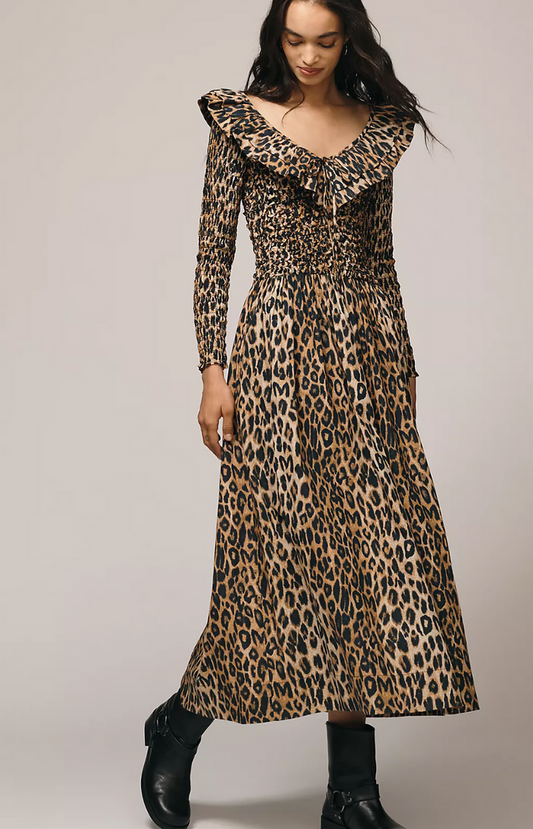 Woman wearing a leopard print dress against a plain background