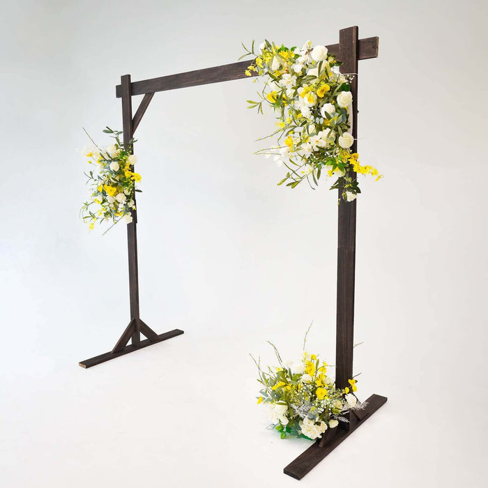 Wooden wedding arch with floral arrangements in yellow and white