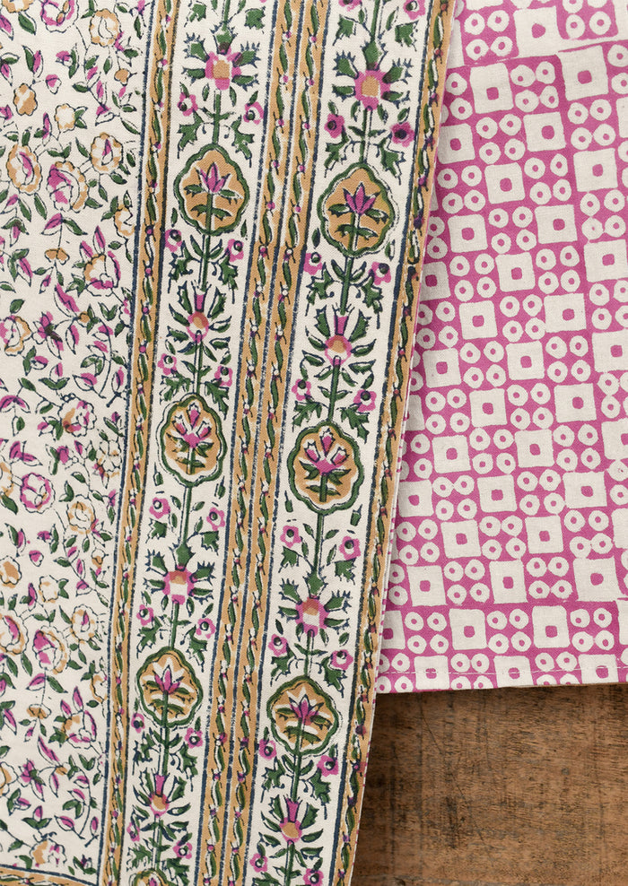 Two pieces of fabric with intricate patterns on a wooden surface