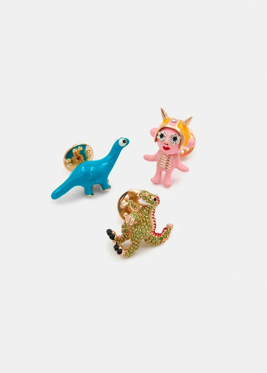 Three colorful dinosaur charm pins on a white background