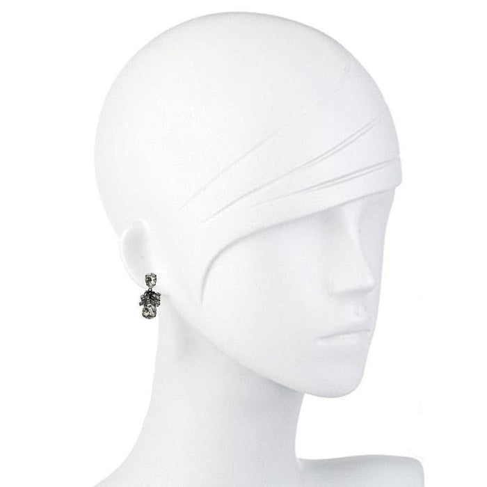 Elegant dark gray crystal earrings on a white mannequin.