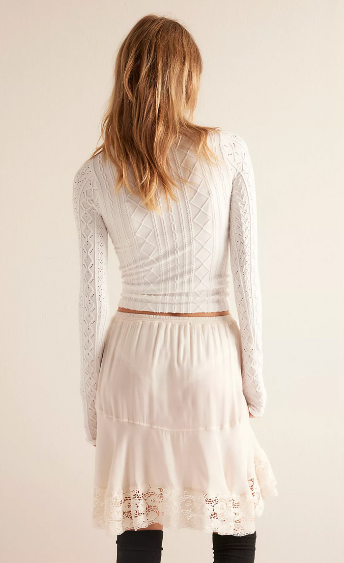 Woman wearing a sugar lace slip with a plain background